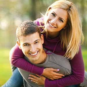 Younger couple smiling after having their wisdom teeth removed