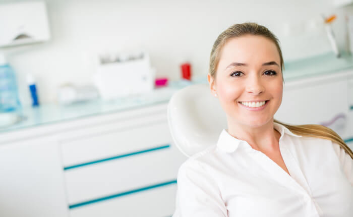 blonde woman in dental chair to improve oral and overall health
