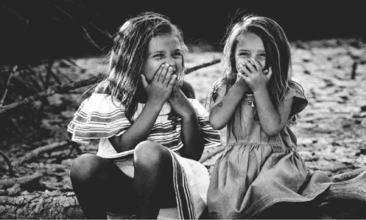 two young girls holding their mouths with dental sealants