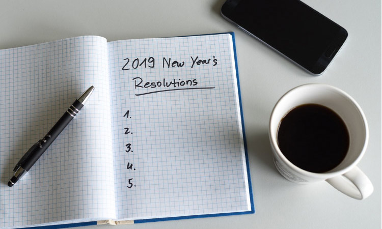 2019 new year resolutions notebook, a pen, cup of coffee and cell phone