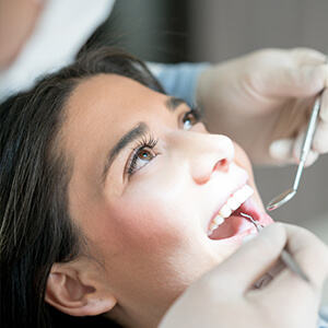 woman having her teeth examined by a dentist