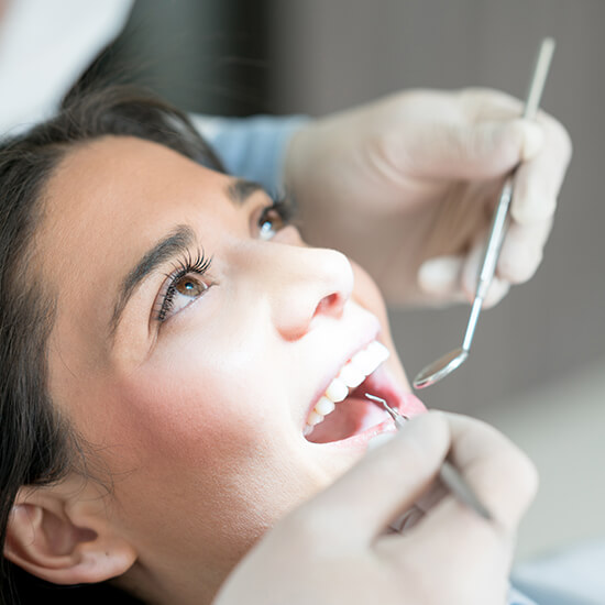 woman having her teeth examined by a dentist