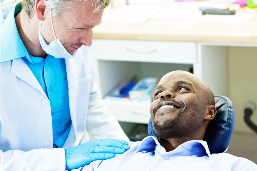 man sitting in the dentist chair discusses restorative dentistry with the dentist