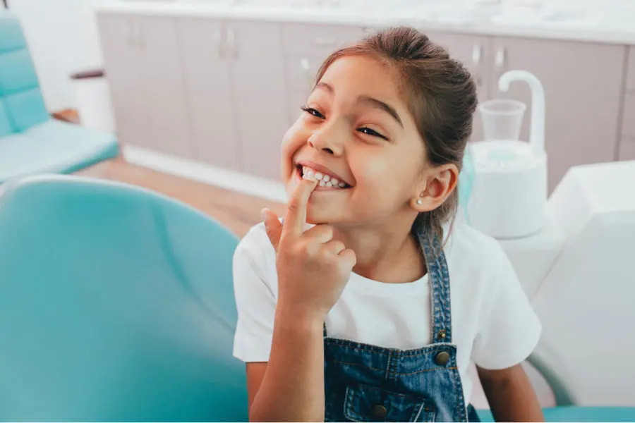 young girl pointing to her front teeth