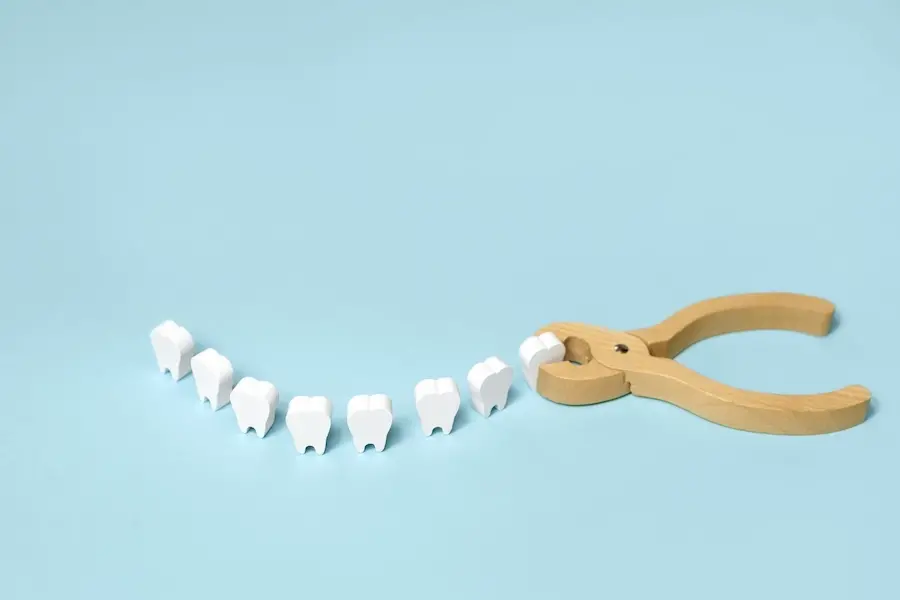 wisdom tooth removal, image of wooden teeth with pliers for oral surgery